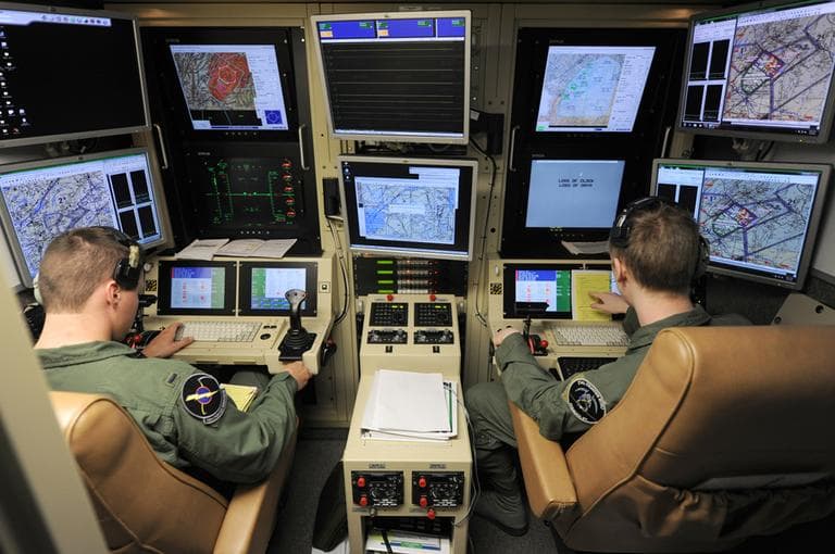 A student pilot and sensor operator man the controls of a MQ-9 Reaper in a ground-based cockpit during a training mission flown from Hancock Field Air National Guard Base in Syracuse, New York, in June. (AP/TSgt Ricky Best, Defense Department)