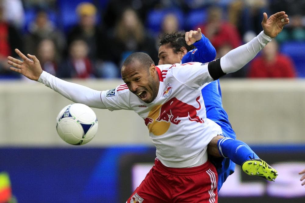 New York Red Bulls forward Thierry Henry is hit from behind by a Montreal Impact player during an MLS game in New Jersey. (Mel Evans/AP)