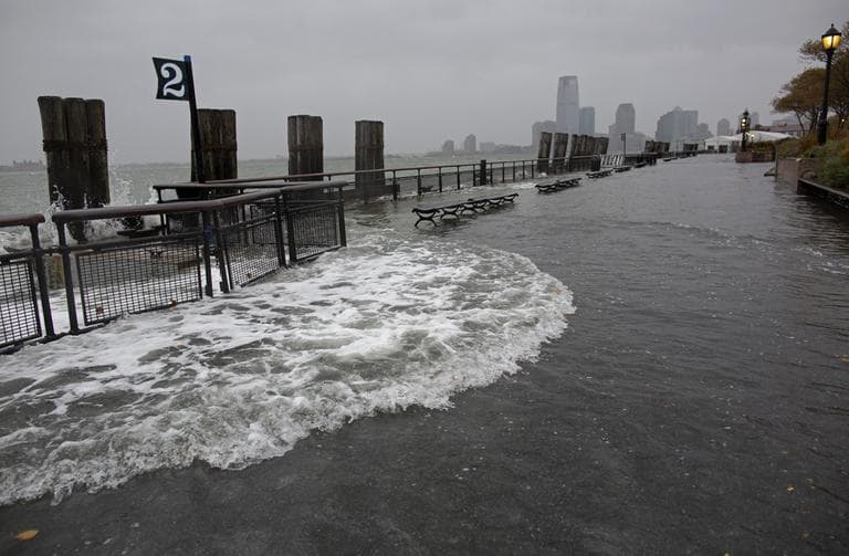 Waves wash over the seawall near high tide at Battery Park in New York on Monday. (Craig Ruttle/AP)
