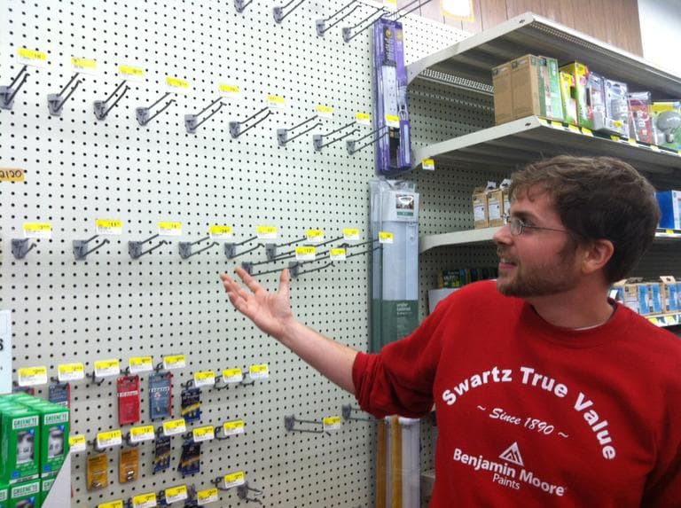 Jeremy Perry shows the now-empty flashlight section at Swartz Hardware in Newton Monday. (Andrea Shea/WBUR)