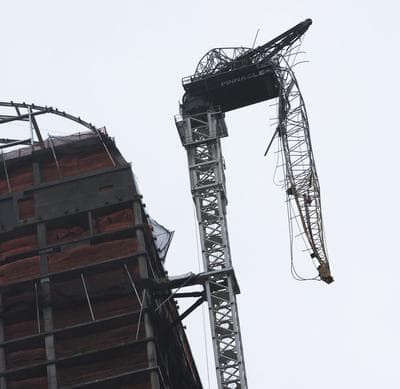 A construction crane atop a luxury high-rise dangles precariously over the streets after collapsing in high winds from Hurricane Sandy on Monday. (John Minchillo/AP)