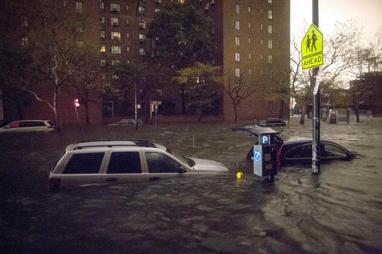 Vehicles are submerged on 14th Street near the Consolidated Edison power plant on Monday in New York. (John Minchillo/AP)