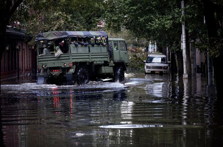 Members of the National Guard and Hoboken Police ride a large truck through floodwaters used to pluck people from high water in Hoboken, N.J., Wednesday, Oct. 31, 2012, in the wake of superstorm Sandy. Parts of the city are still covered in standing water, trapping some residents in their homes. (Craig Ruttle/AP)