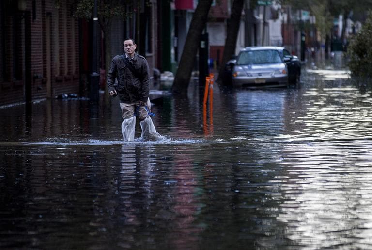 David Bagatelle, of Hoboken, N.J., walks from his residence on Park Avenue through high water in Hoboken, N.J., on Wednesday, in the wake of superstorm Sandy. Bagatelle's home is surrounded by water, but dry, where his wife and seven day old baby are staying. (Craig Ruttle/AP)