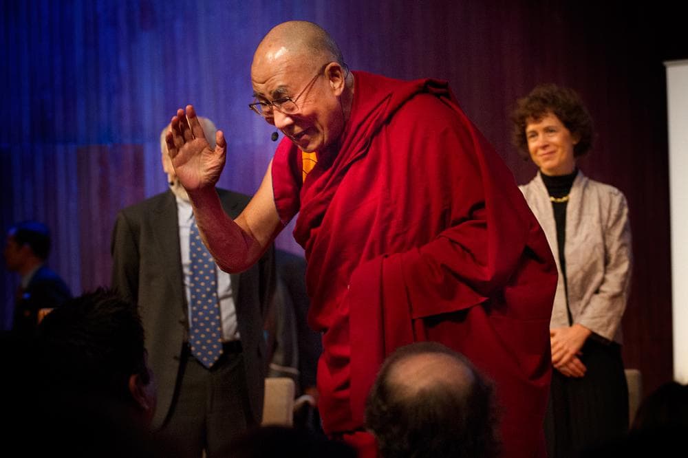 Tibetan exiled spiritual leader the Dalai Lama waves as he takes the stage for the &quot;Ethics, Economy and Environment Panel&quot; at the Global Systems 2.0 Conference at MIT on Monday. (Jesse Costa/WBUR)