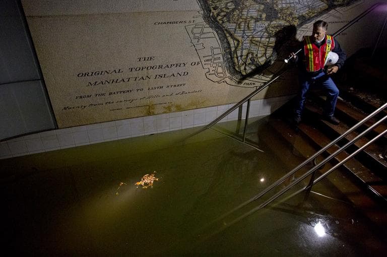 Joseph Leader, MTA vice president and chief maintenance officer, shines a flashlight on standing water inside the South Ferry 1 train station in New York. (Craig Ruttle/AP)
