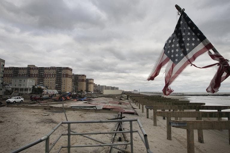 A damaged flag stands among the remnants of the boardwalk on Rockaway Beach, in the Queens borough of New York, on Wednesday. (Frank Franklin II/AP)