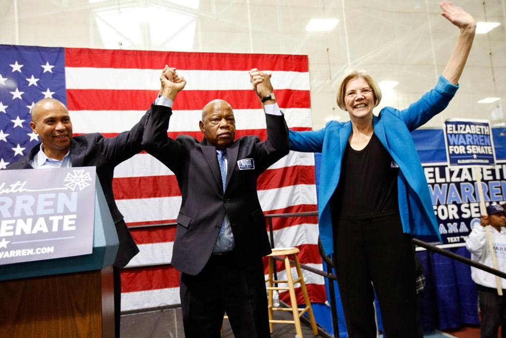 Elizabeth Warren joins hands with U.S. Rep. John Lewis, D-Ga. (center) and Gov. Deval Patrick (left) after speaking during a campaign rally in Boston on Saturday. (Michael Dwyer/AP)