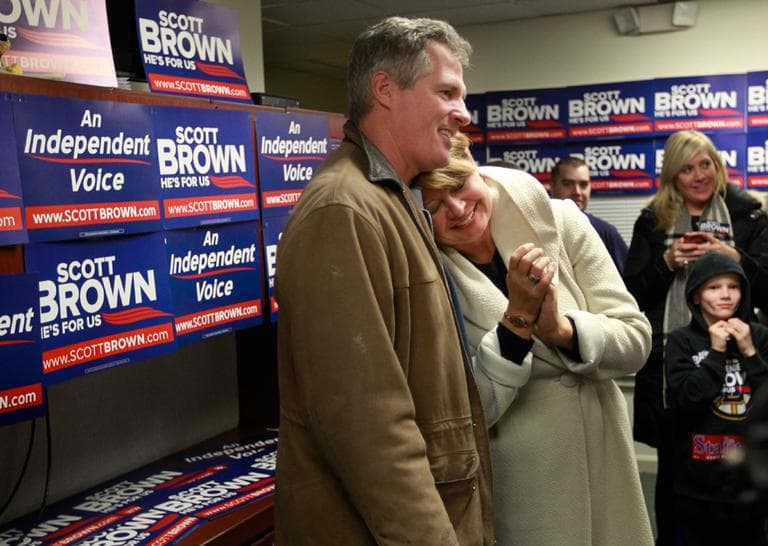 U.S. Sen. Scott Brown and his wife, Gail Huff, speak with supporters at a Brown campaign office in Walpole Monday. (Steven Senne/AP)