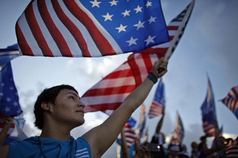 A pro-statehood New Progressive Party supporter waves the U.S. flag during the party's closing campaign rally in San Juan, Puerto Rico, on Saturday. (Ricardo Arduengo/AP)