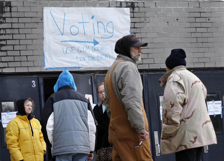 People, many displaced from the Jersey Shore by Superstorm Sandy, stand outside the shelter where they are staying at Toms River East High School on Tuesday, in Toms River, N.J. The school is also a polling station for elections. (Mel Evans/AP)