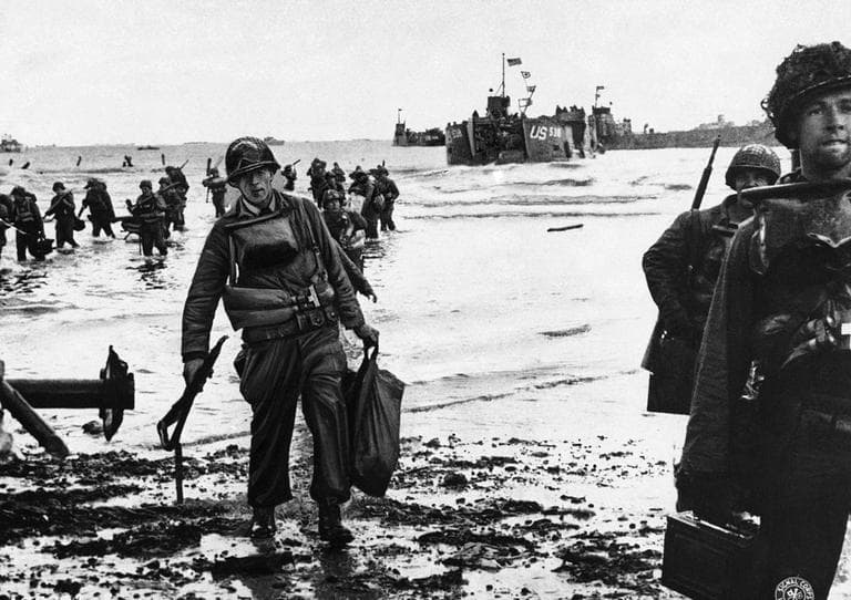 U.S. assault troops, laden with equipment, wade through the surf to a Normandy beach from landing craft in June 1944 to support those who had gone before in the D-Day assault. (AP)
