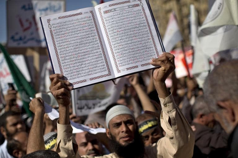 An Egyptian Muslim man holds the Quran during a rally in Tahrir Square in Cairo on Friday. Thousands of ultraconservative Muslims rallied in the Egyptian capital, demanding the country's new constitution be based on the rulings of Islamic law, or Shariah. (Bernat Armangue/AP)