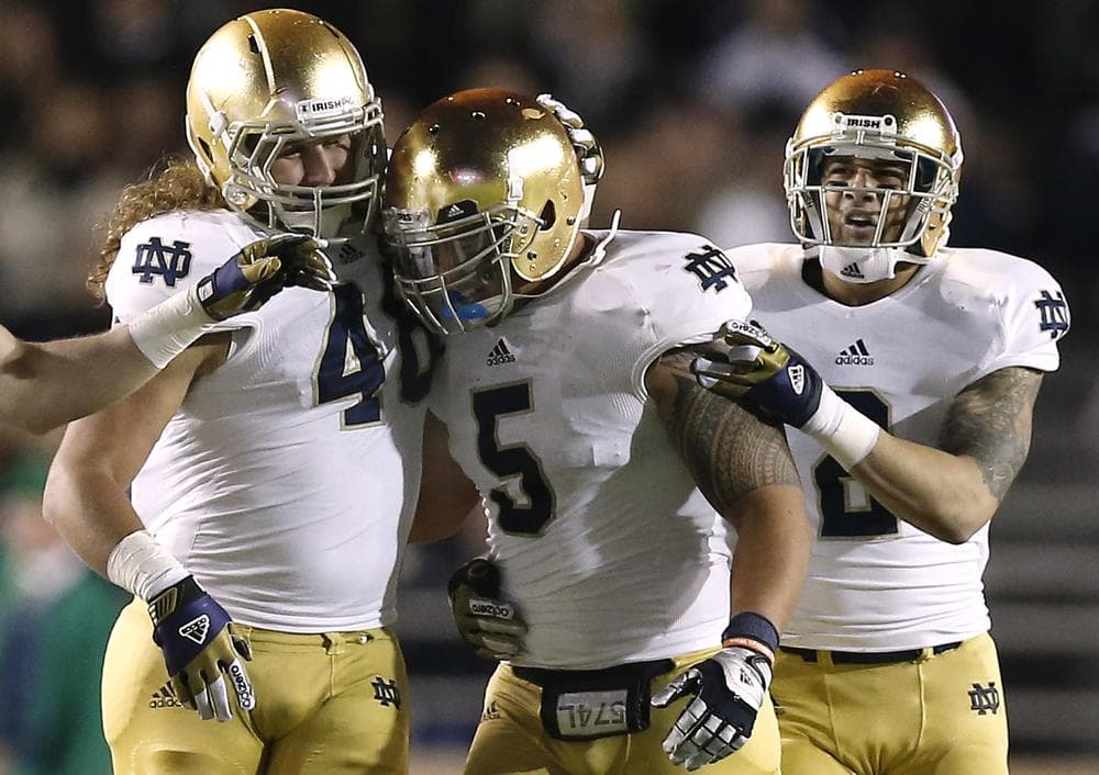 Teammates congratulate Notre Dame linebacker Manti Te'o for an interception during a game against Boston College. Notre Dame won 21-6 and are 10-0 this season. (Winslow Townson/AP)