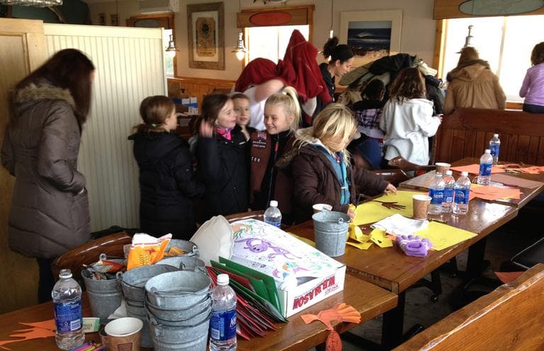 Girl Scouts and moms make placemats inside the Mud City Crab House in Manahawkin, N.J. in preparation for the Thanksgiving dinner there on Thursday. (Chris Ballman/Here & Now)