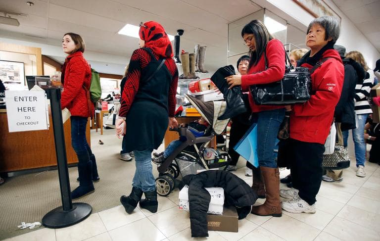 Shoppers wait in the checkout line at Macy's in downtown Boston on Friday. (Michael Dwyer/AP)