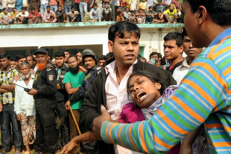 People console a woman whose relative was killed in a fire at a garment factory outside Dhaka, Bangladesh. (AP Photo/Hasan Raza)