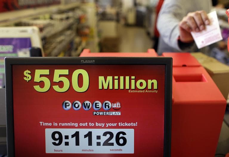 Store clerk Keyur Patel pulls a Powerball ticket that was dispensed from a machine in a convenience store in Baltimore on Wednesday. (Patrick Semansky/AP)