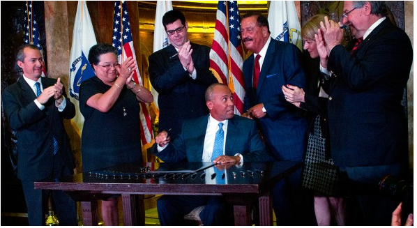 Gov. Deval Patrick signs a sweeping health care cost-containment law. (Photo: Jesse Costa/WBUR)