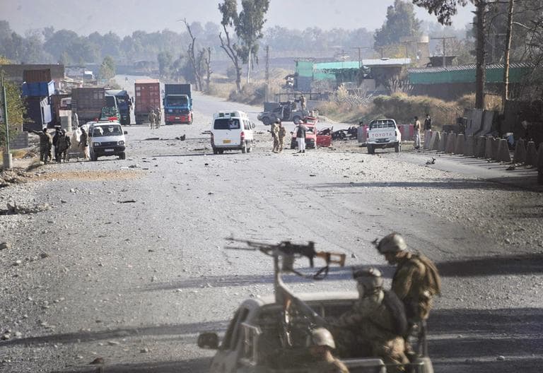 Afghan security forces block the road where Taliban suicide bombers attacked a joint U.S.-Afghan air base in Jalalabad, east of Kabul, Afghanistan on Sunday. (Nasrullah Khan/AP)