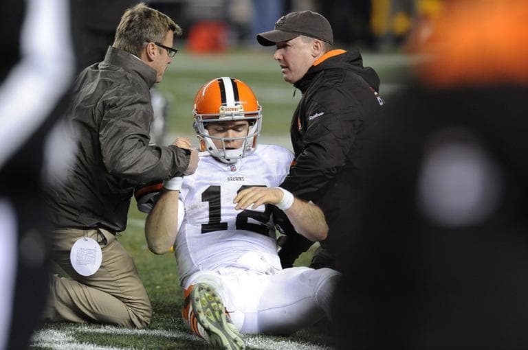 In December 2011, trainers tend to Cleveland Browns quarterback Colt McCoy after he was hit by Pittsburgh Steelers outside linebacker James Harrison in the fourth quarter of an NFL football game in Pittsburgh. (Don Wright/AP)