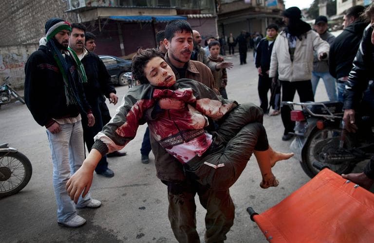 A man carries a boy who was severely wounded during heavy fighting between Syrian rebels and government forces in Idlib, north Syria. Sunday, March 11, 2012.  (AP Photo/Rodrigo Abd)