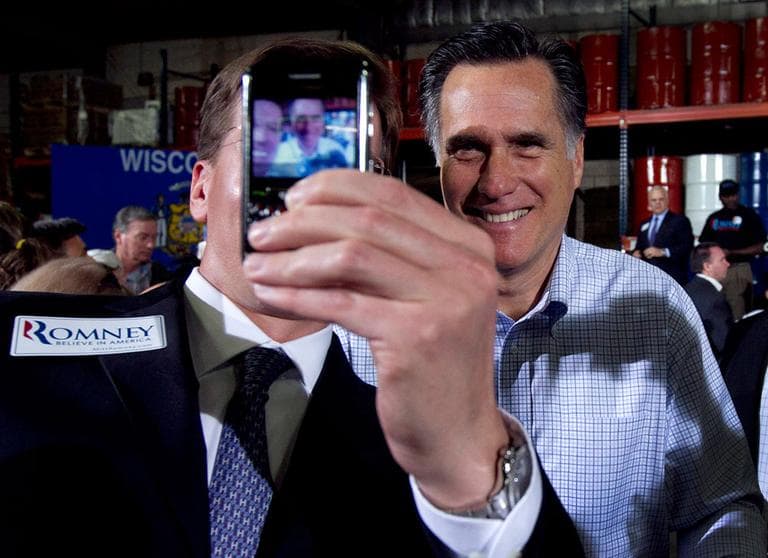 A member of the audience uses a mobile phone to record an image of himself with Republican presidential candidate, former Massachusetts Gov. Mitt Romney at the conclusion of a campaign event at an oil company in Milwaukee, Monday, April 2, 2012. (AP Photo/Steven Senne)