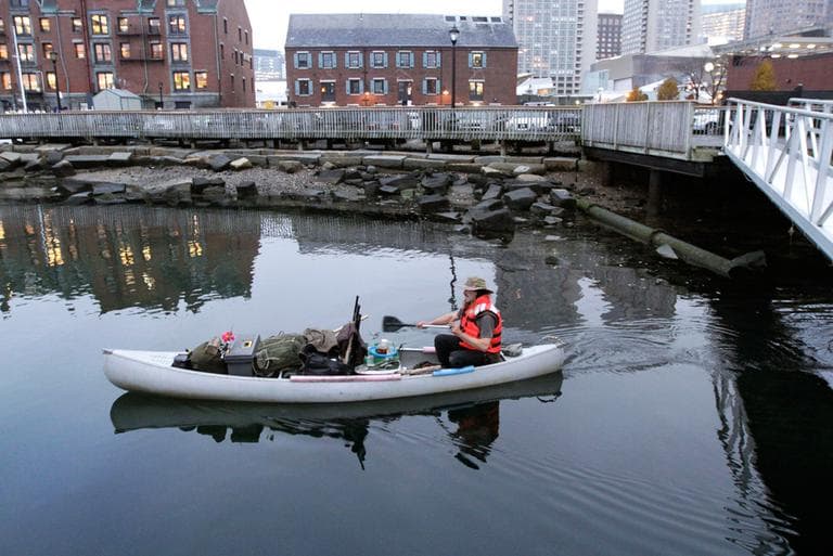 Michael Richard Smith pilots his canoe in Boston Harbor on Tuesday. The 49-year-old Maine native said he’s been paddling the waters of metro Boston since at least late summer with all of his possessions aboard a 14-foot, 40-year-old aluminum canoe that he patches with duct tape when necessary. (Steven Senne/AP)
