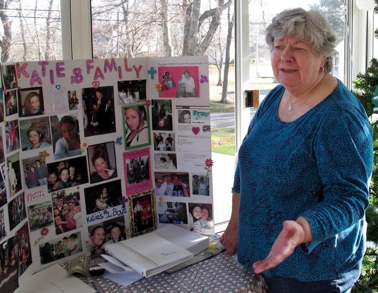 On the porch of her home in Weymouth, Mary Johansen looks at a photo collage of her daughter Katie, who died of a heroin overdose at the age of 22. (Monica Brady-Myerov/WBUR)