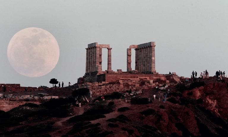 A full moon rises behind the Temple of Poseidon in Cape Sounion, south east of Athens, Greece, while tourists watch, on Saturday, May 5, 2012. Saturday's event is a &quot;supermoon,&quot; the closest and therefore the biggest and brightest full moon of the year. (AP Photo/Dimitri Messinis)