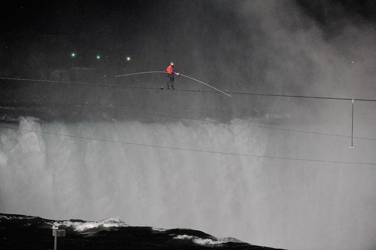Nik Wallenda walks across NiagaraFalls on a tightrope as seen from NiagaraFalls, N.Y., Friday, June 15, 2012. Wallenda has finished his attempt to become the first person to walk on a tightrope 1,800 feet across the mist-fogged brink of roaring NiagaraFalls. (AP Photo/Gary Wiepert)