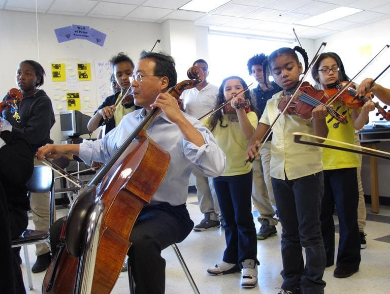 Yo-Yo Ma plays with orchestra students at the Orchard Gardens school Thursday. The famed cellist is part of a two-year musical exchange with students at the school, which has been designated as a Turnaround Arts school by the Obama administration. (Monica Brady-Myerov/WBUR)