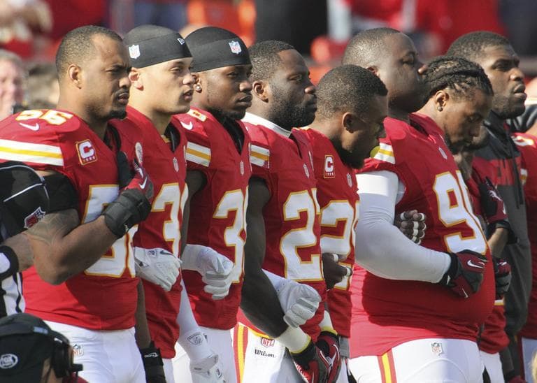 Kansas City Chiefs players stand arm-in-arm during a moment of silence before last Sunday's game with the Carolina Panthers. (Colin E. Braley/AP)