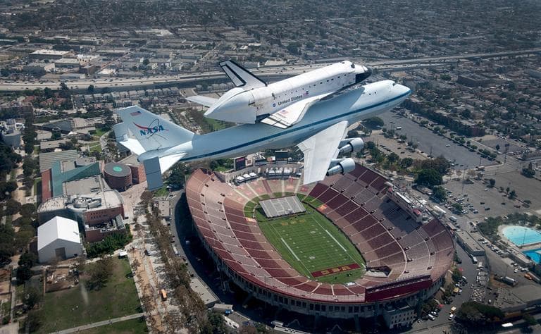 The space shuttle Endeavour atop the 747 shuttle carrier aircraft is seen flying over the LA Coliseum in Los Angeles during the final portion of its tour of California, Friday, Sept. 21, 2012. (AP Photo/NASA, Jim Ross)