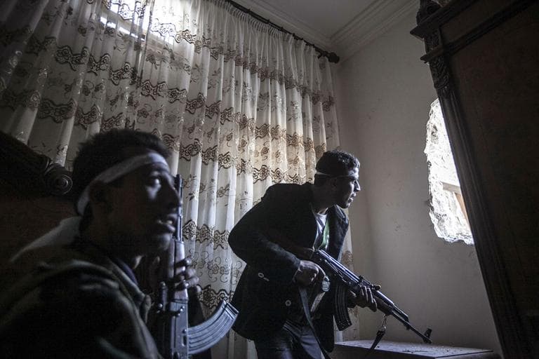 In this Thursday, Nov. 1, 2012 photo, rebel fighters watch over enemy positions as they wait for Syrian army troops to enter a street during clashes in the Karmal Jabl battlefield in Aleppo, Syria. (AP)