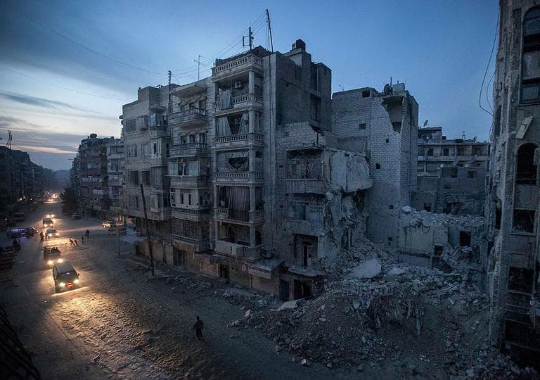 Night falls on a Syrian rebel-controlled area as destroyed buildings, including Dar Al-Shifa hospital, are seen on Sa'ar street after airstrikes targeted the area, killing dozens in Aleppo, Syria. Nov. 29, 2012. (AP Photo/Narciso Contreras)