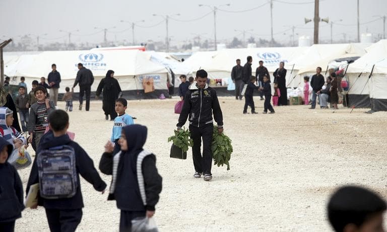 A Syrian refugee carries greens to family's tent at Zaatari Syrian Refugee Camp, in Mafraq, Jordan, Nov. 27, 2012.  (AP/Mohammad Hannon)