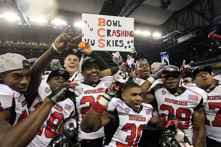 Northern Illinois players poses for photographers after defeating Kent State and qualifying for the Orange Bowl. (AP/Carlos Osorio)