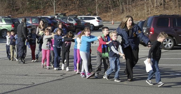 In this photo provided by the Newtown Bee, Connecticut State Police lead children from the Sandy Hook Elementary School in Newtown, Conn., following a reported shooting there Friday, Dec. 14, 2012. (AP Photo/Newtown Bee, Shannon Hicks)