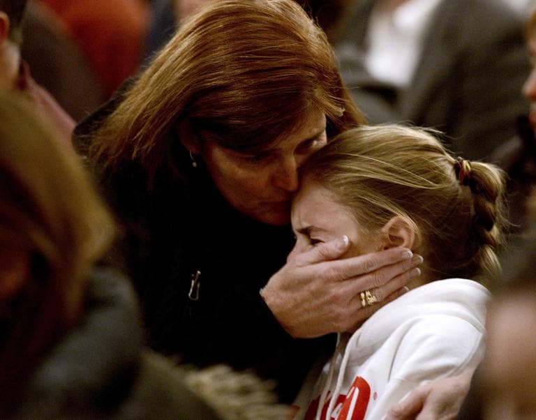 A woman comforts a young girl during a vigil service for victims of the Sandy Hook Elementary shooting, Friday, Dec. 14, 2012, at St. Rose of Lima Roman Catholic Church in Newtown, Conn. (Andrew Gombert, Pool/AP)