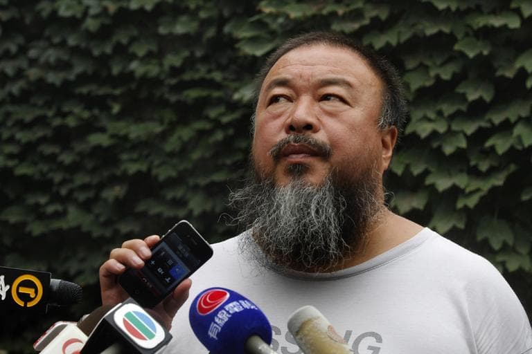 Dissident artist Ai Weiwei listens as his lawyer announces over a speakerphone the verdict of Ai's lawsuit against the Beijing tax authorities in Beijing Friday, July 20, 2012. A Beijing court on Friday rejected an appeal by Ai against a more than $2 million fine for tax evasion, which he says is part of an intimidation campaign to stop him from criticizing the government. (AP)