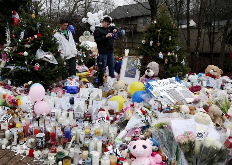 Ryan Bartolotta, 17, right, and Ray Massi, 18, light up candles that were put out by rain at a makeshift memorial in the Sandy Hook village of Newtown, Conn., as the town mourns victims killed in a school shooting. (Julio Cortez./AP)