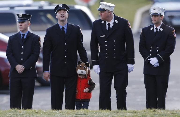 A child lines up with firefighters outside the funeral for school shooting victim Daniel Gerard Barden,at St. Rose of Lima Catholic Church in Newtown, Conn., Wednesday, Dec. 19, 2012. According to firefighters, Daniel wanted to be a firefighter when he grew up and they honored him at the service. Gunman Adam Lanza opened fire killing 26 people, including 20 children, at Sandy Hook Elementary School in Newtown before killing himself on Friday. (AP)