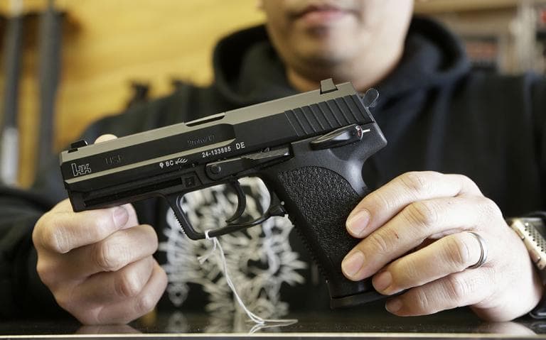 General manager Steve Alcairo holds an HK USP 9mm handgun while being interviewed at High Bridge Arms Inc. in San Francisco on Wednesday. (Jeff Chiu/AP)