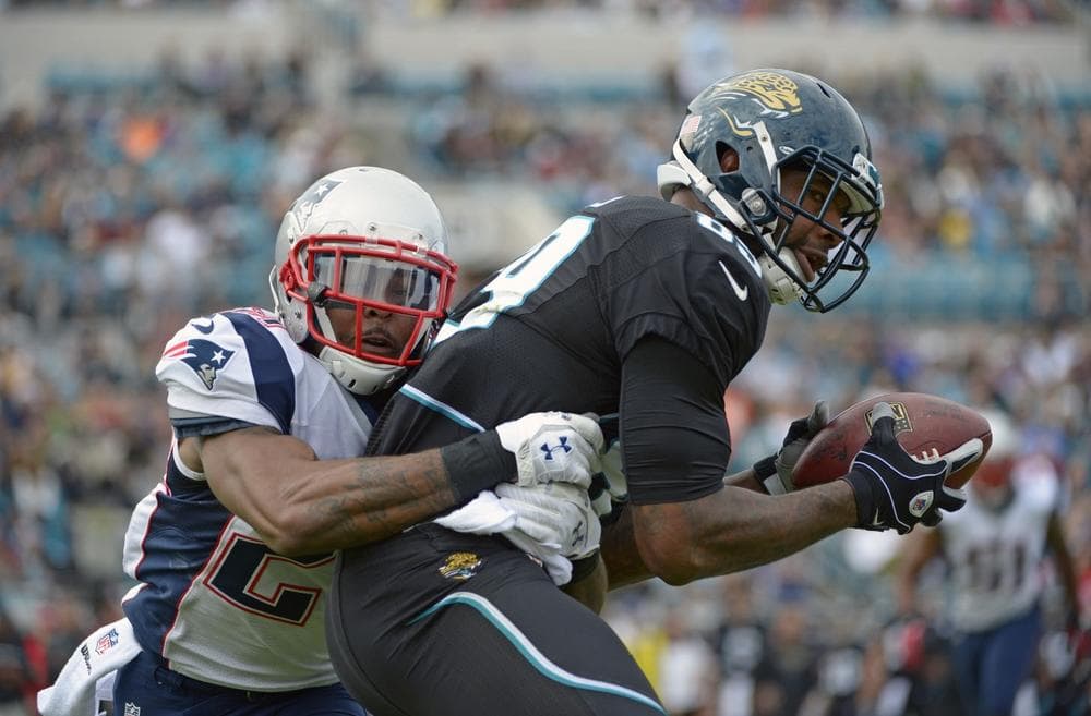 Jaguars tight end Marcedes Lewis catches a pass as he is tackled by Patriots strong safety Tavon Wilson during the first half of Sunday's game in Jacksonville, Fla. (Phelan M. Ebenhack/AP)