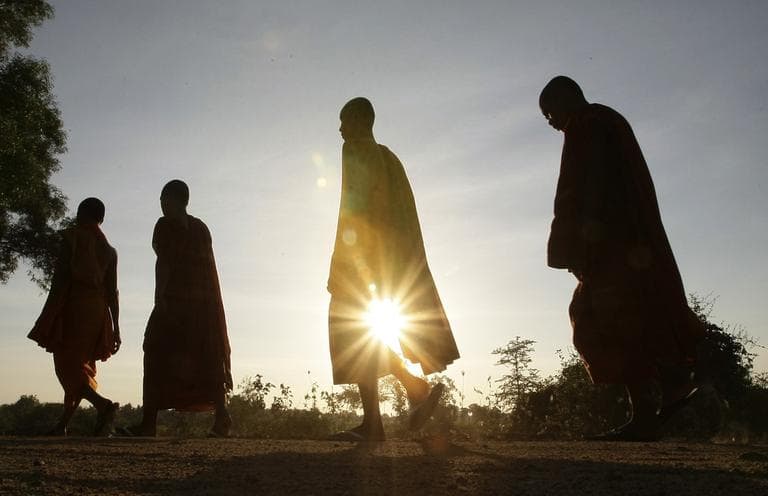 Cambodian Buddhist monks are silhouetted as they walk at the outskirt of Phnom Penh, Cambodia, Tuesday, Dec. 18, 2012. (Heng Sinith/AP)