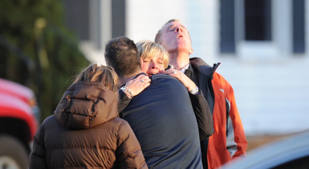 Unidentified people embrace on December 14, 2012 at the aftermath of  a school shooting at a Connecticut elementary school. At least 27 people, including 18 children, were killed on Friday when at least one shooter opened fire at an elementary school in Newtown, Connecticut, CBS News reported, citing unnamed officials. (Don Emmert/AFP via Getty Images)