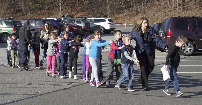 Connecticut State Police lead children from the Sandy Hook Elementary School in Newtown, Conn., following a reported shooting there Friday, Dec. 14, 2012. (AP Photo/Newtown Bee, Shannon Hicks)