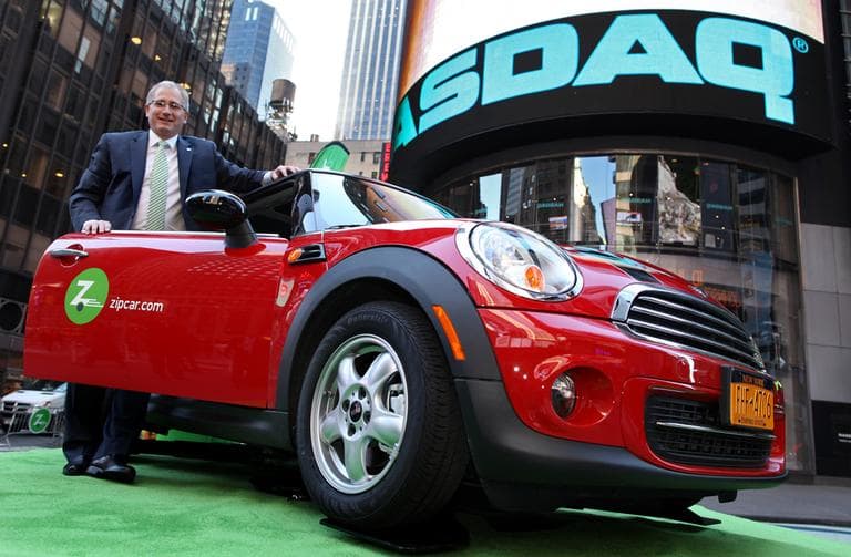 The boards of Zipcar and Avis unanimously approved the $491.2 million buyout. Here, Zipcar Chairman and CEO Scott Griffith stands with a Zipcar Mini-Cooper before the opening bell at the NASDAQ Market Site in New York in 2011.  (AP Photo/Zipcar.com, Craig Ruttle, File)