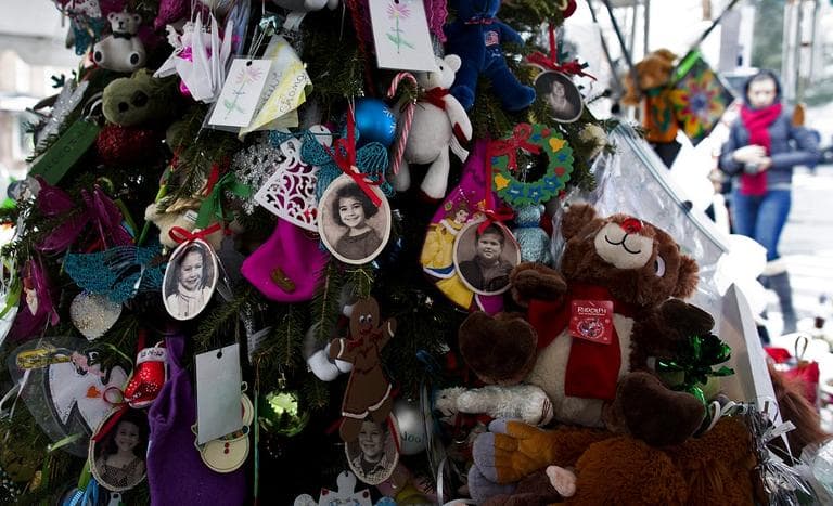 Portraits of slain students and teachers hang from a tree at a memorial in Newtown, Conn., Dec. 25, 2012. (Craig Ruttle/AP)